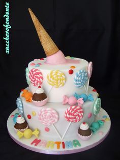 a birthday cake decorated with candies, lollipops and an ice cream cone