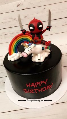 a birthday cake with a deadpool figure on top