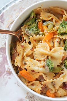 a white bowl filled with pasta and vegetables