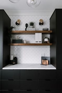 black and white kitchen with open shelving, marble countertops and wooden shelves on the wall