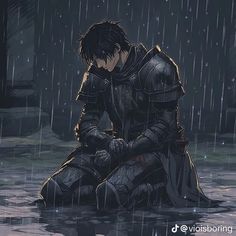 a man sitting on the ground in the rain