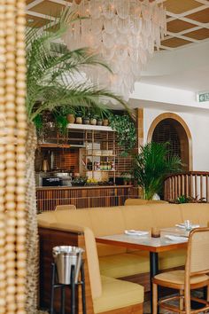 the inside of a restaurant with tables, chairs and chandelier hanging from the ceiling