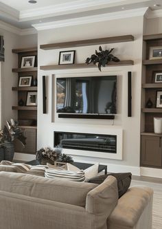 a living room filled with furniture and a flat screen tv mounted on a wall above a fireplace