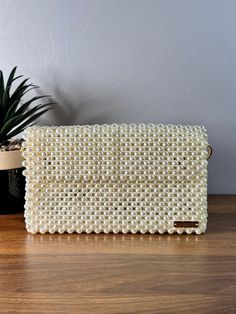 Elegance meets opulence in this beaded pearl bag. Elevate your style with a touch of sophistication and luxury. Dimension: Width: 22cm Height: 12.5cm Depth: 6cm The bag comes with a detachable handle which measures 110cm. Feel free to contact me for any questions. Pearl Beaded Evening Bag For Formal Occasions, Formal Beaded Pearl Evening Bag, Luxury Pearl Embellished Clutch Shoulder Bag, Chic Rectangular Clutch With Pearl Embroidery, Chic Rectangular Pearl Clutch, Chic Beige Pearl Evening Bag, Luxury Evening Bag With Pearl Embroidery, Luxury Pearl Clutch With Pearl Handle, Chic Clutch With Pearl Embroidery