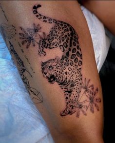 a black and white photo of a tattoo on the arm of a woman with a leopard