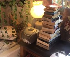 a stack of books sitting on top of a table next to a lamp