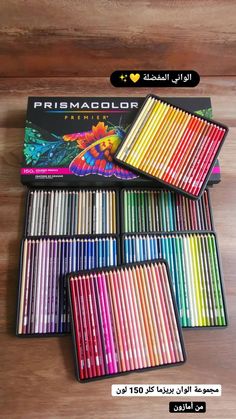 a box of colored pencils on top of a wooden table next to each other