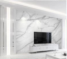 a living room with marble walls and white furniture in the center, along with a flat screen tv