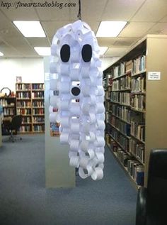 a room filled with lots of books and a light fixture made out of plastic cups