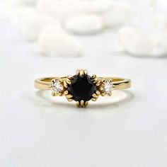 a black diamond ring sitting on top of a white surface