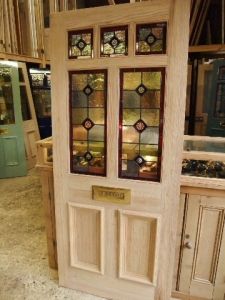 a wooden door with stained glass panels on the front and side doors, in a store