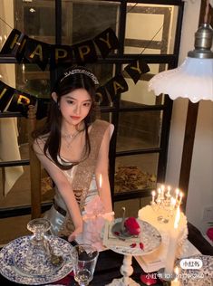 a woman is sitting in front of a cake with candles on it and the words happy birthday are above her