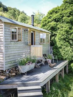 a small wooden house sitting on top of a lush green hillside