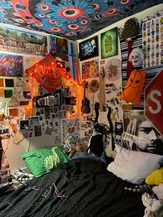 a bed room with a neatly made bed and lots of pictures on the wall above it