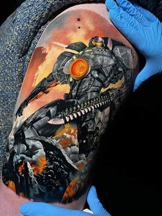 a man with blue gloves on his hands and tattoos on his arm is holding up a tattoo