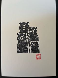 two black bears standing next to each other in front of a red stamp on white paper