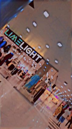 an image of people walking in front of a light store