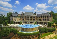 an aerial view of a large mansion with a fountain