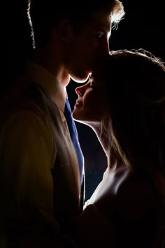 a man and woman kissing in the dark