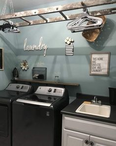 a washer and dryer in a laundry room with pictures on the wall above them