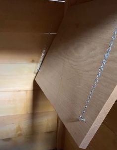 a wooden shelf with chains hanging from it's sides and the bottom section missing