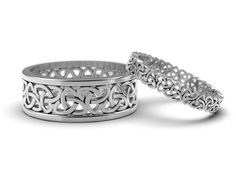 two wedding bands with intricate designs on them, one is white gold and the other is silver