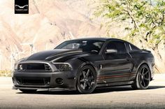 a black mustang parked in front of a mountain