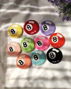 eight ball pool balls laid out on top of a sheet with purple flowers in the background