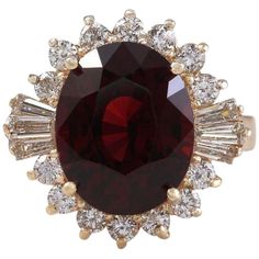 a large red stone surrounded by white and yellow diamonds in a gold ring with an oval center