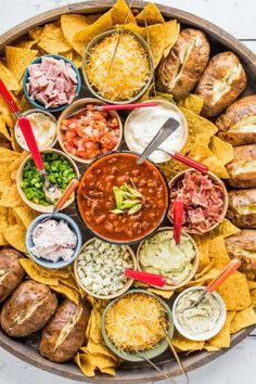 a platter filled with chips, dips and salsa is ready to be served