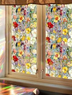 the sun shines through two stained glass windows with flowers on them in front of a window sill