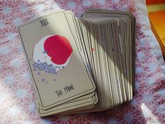 four playing cards sitting on top of a pink and white tablecloth with flowers in the background