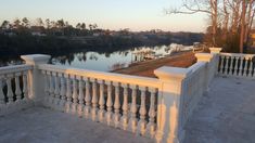 there is a balcony overlooking the water and boats in the lake behind it at sunset