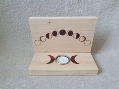 a wooden box with a candle holder in the shape of a crescent moon and phases