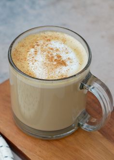 a cup of coffee sitting on top of a wooden table