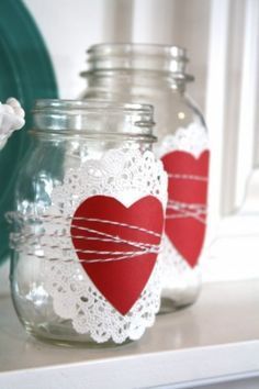 two mason jars decorated with red hearts and twine lace are sitting on a table