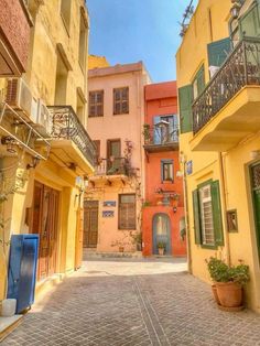 an alleyway in the old part of town with colorful buildings and balconies