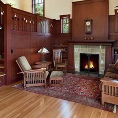 a living room filled with furniture and a fire place next to a stair case in front of a window