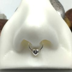 a ring with a heart on it sitting in front of some doughnuts and nuts