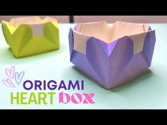 an origami heart box sitting on top of a table next to each other