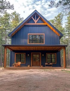 a large blue house sitting in the middle of a forest