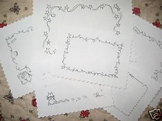 four pieces of paper with designs on them sitting on a tableclothed surface together