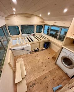 the inside of a boat with wood flooring and windows on each side of it