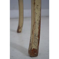 an old wooden stool with rusted paint on it