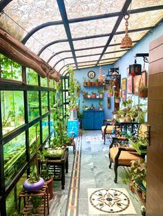 the inside of a greenhouse with lots of potted plants and furniture on display in it