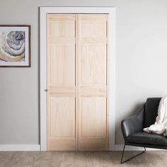 an empty room with a chair and two pictures hanging on the wall next to it