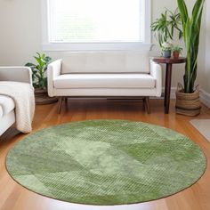 a living room filled with furniture and a green rug on top of a hard wood floor