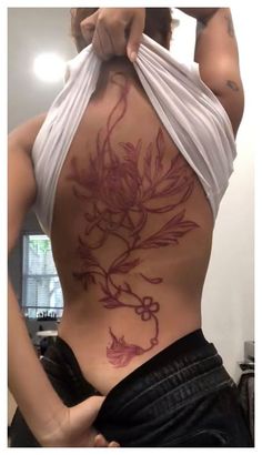 a woman is showing off her back tattoo