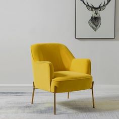 a yellow chair sitting in front of a white wall with a deer head on it