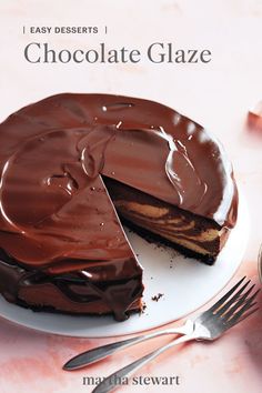 a chocolate glaze cake on a white plate with a slice cut out and ready to be eaten